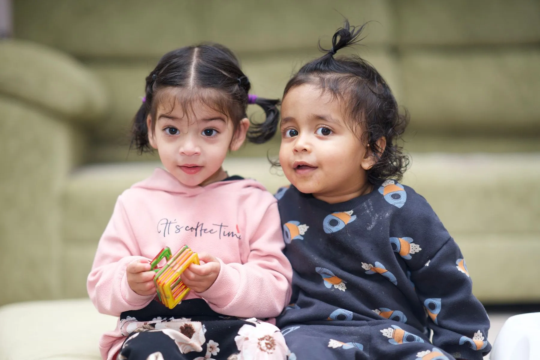 Two little girls playing with toy blocks